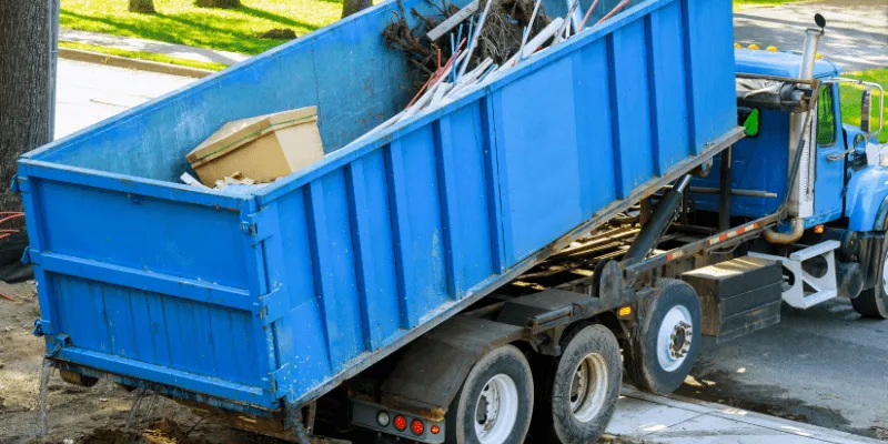 residential dumpster being picked up